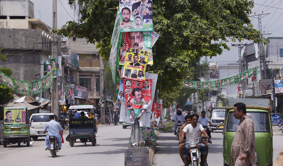 Banners of election candidates from political parties are displayed on a road in Rawalpindi, Pakistan, Tuesday, on July 24, 2018. As Pakistan prepares to make history Wednesday by electing a third straight civilian government, rights activists, analysts and candidates say the campaign has been among its dirtiest ever, imperiling the country's wobbly transition to democratic rule. (AP)
