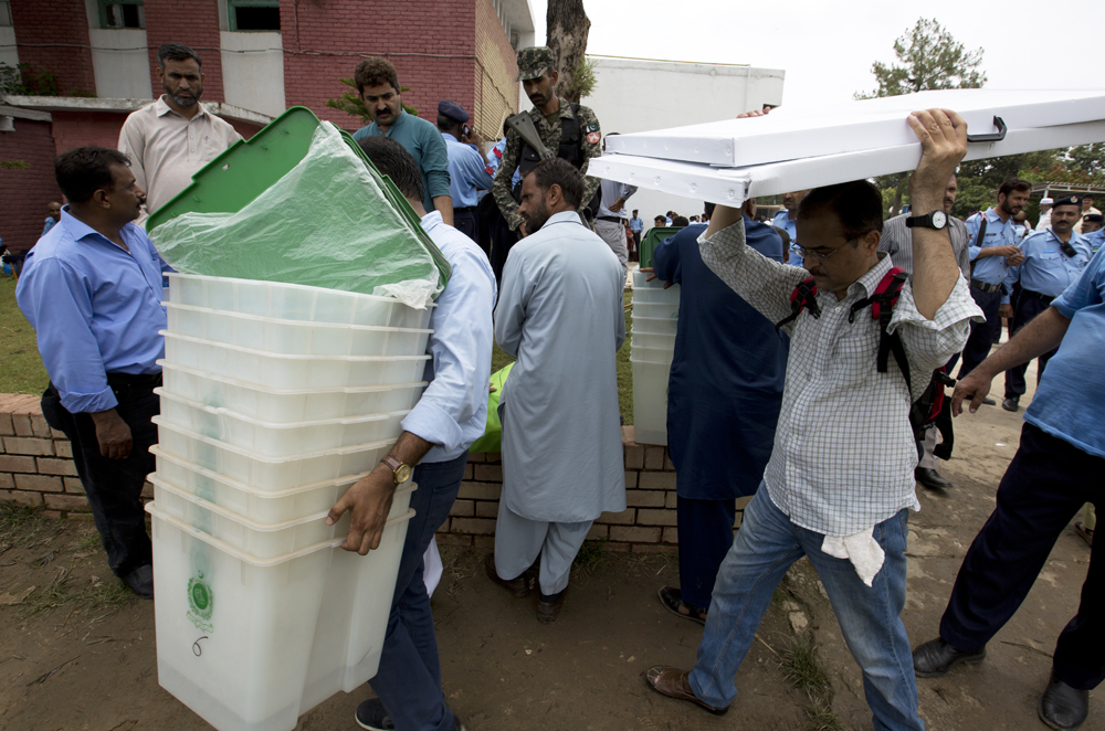 Pakistani election staff carry polling material to stations at a distribution center in Islamabad, Pakistan, on the eve of Pakistan national election on Wednesday. (AP Photo/B.K. Bangash)