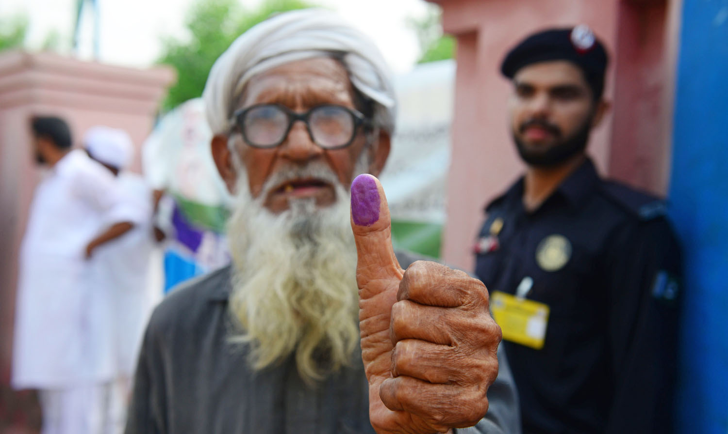 An elderly Pakistani man shows his inked thump after casting his vote outside a polling station during general election in Lahore on July 25, 2018. (ARIF ALI/AFP)