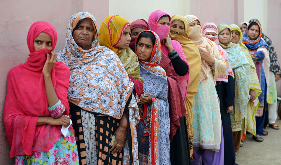 Pakistani women stand in a queue as they wait to cast their vote outside a polling station during general election in Lahore on July 25, 2018. (AFP)