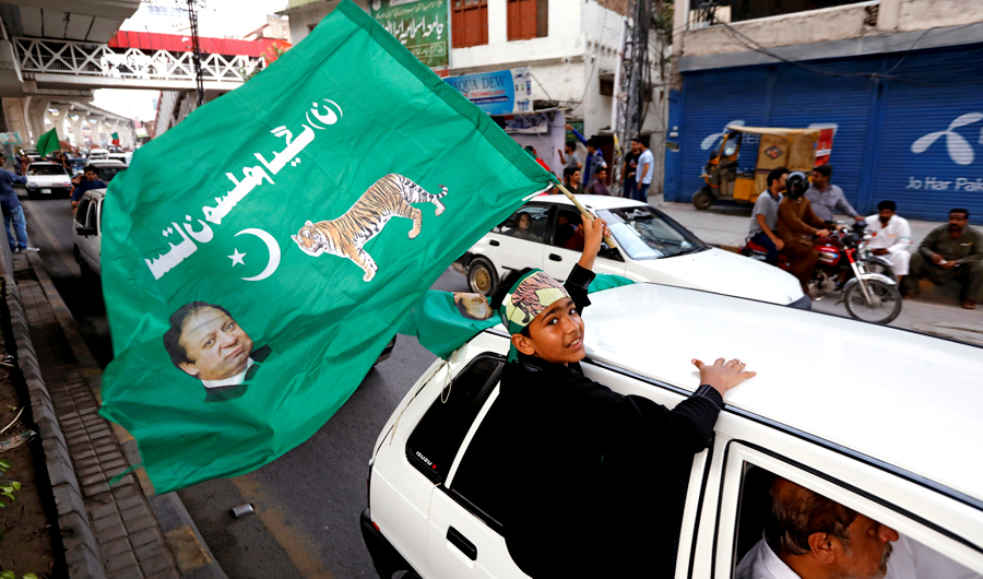 A supporter of Pakistan Muslim League-Nawaz (PML-N), waves a party flag as he celebrates during the general election in Rawalpindi, Pakistan on July 25, 2018. (REUTERS)