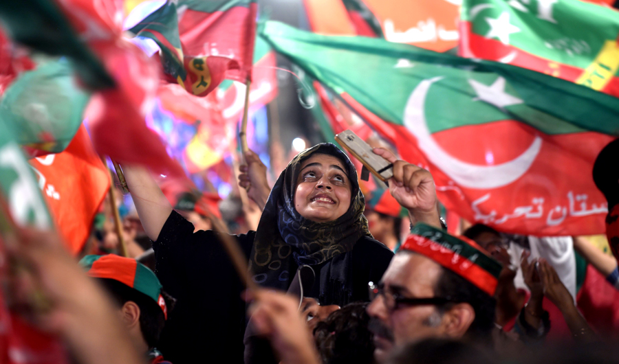 Supporters of Pakistani cricket star-turned-politician and head of the Pakistan Tehreek-e-Insaf (PTI) Imran Khan, cheer and wave flags during a rally during the last campaign day, in Lahore, on July 23, 2018. (AFP)