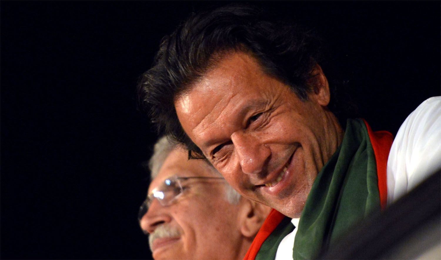 In this file photo, Pakistani opposition politician Imran Khan smiles onstage during an anti-government protest in front of the Parliament in Islamabad on August 28, 2014. (AAMIR QURESHI/AFP)