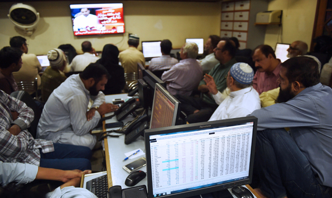 Pakistani stockbrokers look at share prices on computer monitors during a trading session at the Pakistan Stock Exchange (PSX) in Karachi on July 26, 2018, a day after general election. Asian stocks mostly fell on July 26 as investor relief at US President Donald Trump and the European Commission chief's plan to ease trade tensions was offset by disappointing Wall Street earnings. (AFP / RIZWAN TABASSUM)