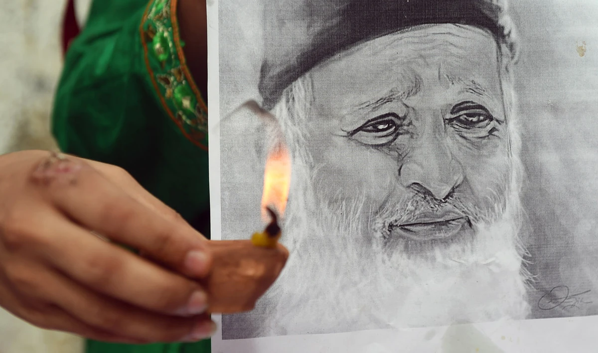 In this file photo, a Pakistani woman holds an oil lamp during a candlelight vigil for renowned social worker Abdul Sattar Edhi in Karachi on July 12, 2016. (RIZWAN TABASSUM/AFP)