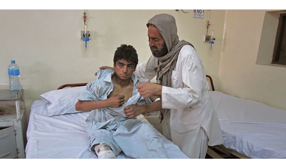 A youth injured in Friday’s blast is cared for by a relative at a hospital in Quetta. (AFP)
