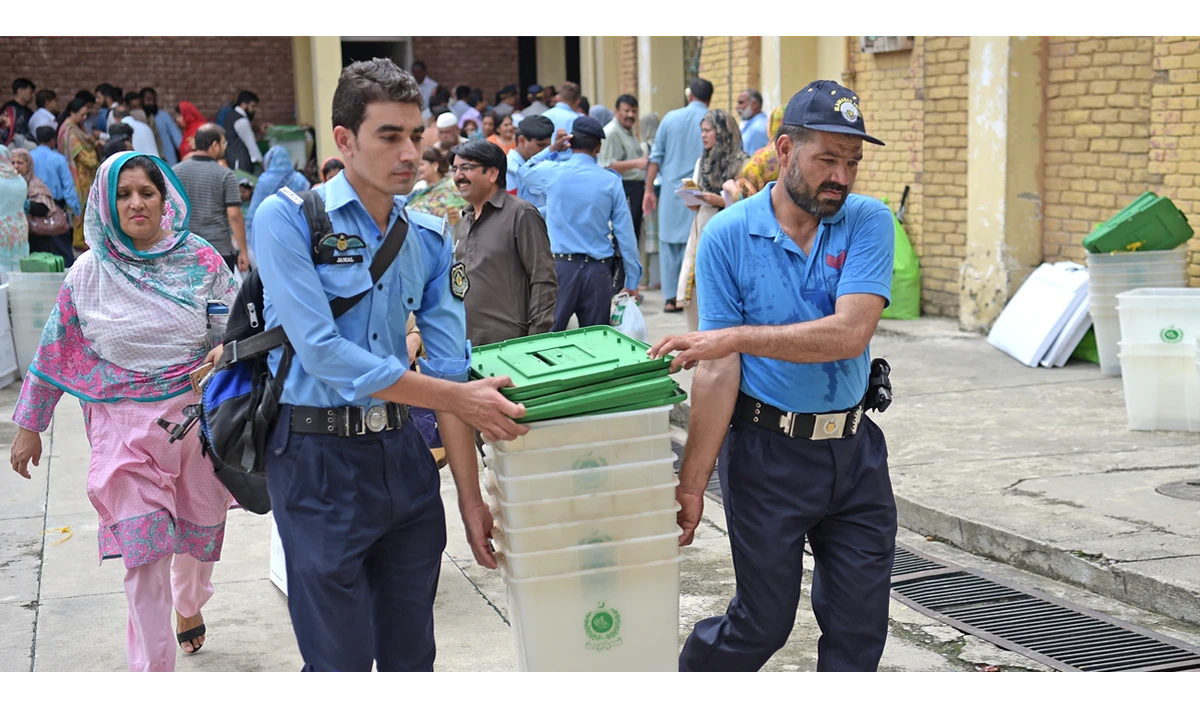 Pakistani policemen help election officials to carry ballot boxes at a distribution centre in Islamabad on July 24, 2018. (AAMIR QURESHI/AFP)