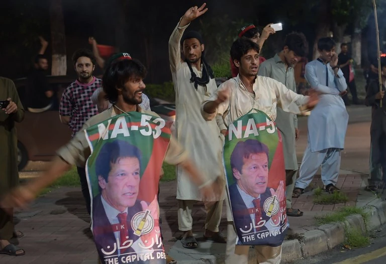 Supporters of Pakistan's cricketer-turned politician Imran Khan, head of the Pakistan Tehreek-e-Insaf (Movement for Justice) party, celebrate on a street during general election in Islamabad on July 25, 2018. (AFP)