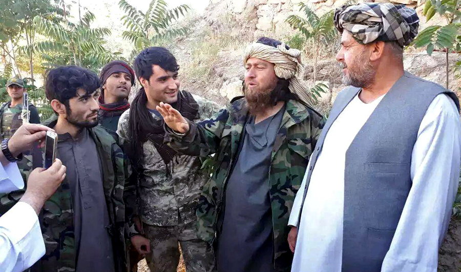 A foreign Daesh group fighter, second right, speaks to a journalist after he surrendered to government security forces in the Darzab district of Jawzjan province, north of Kabul, Afghanistan, on Aug. 1, 2018. (AP)
