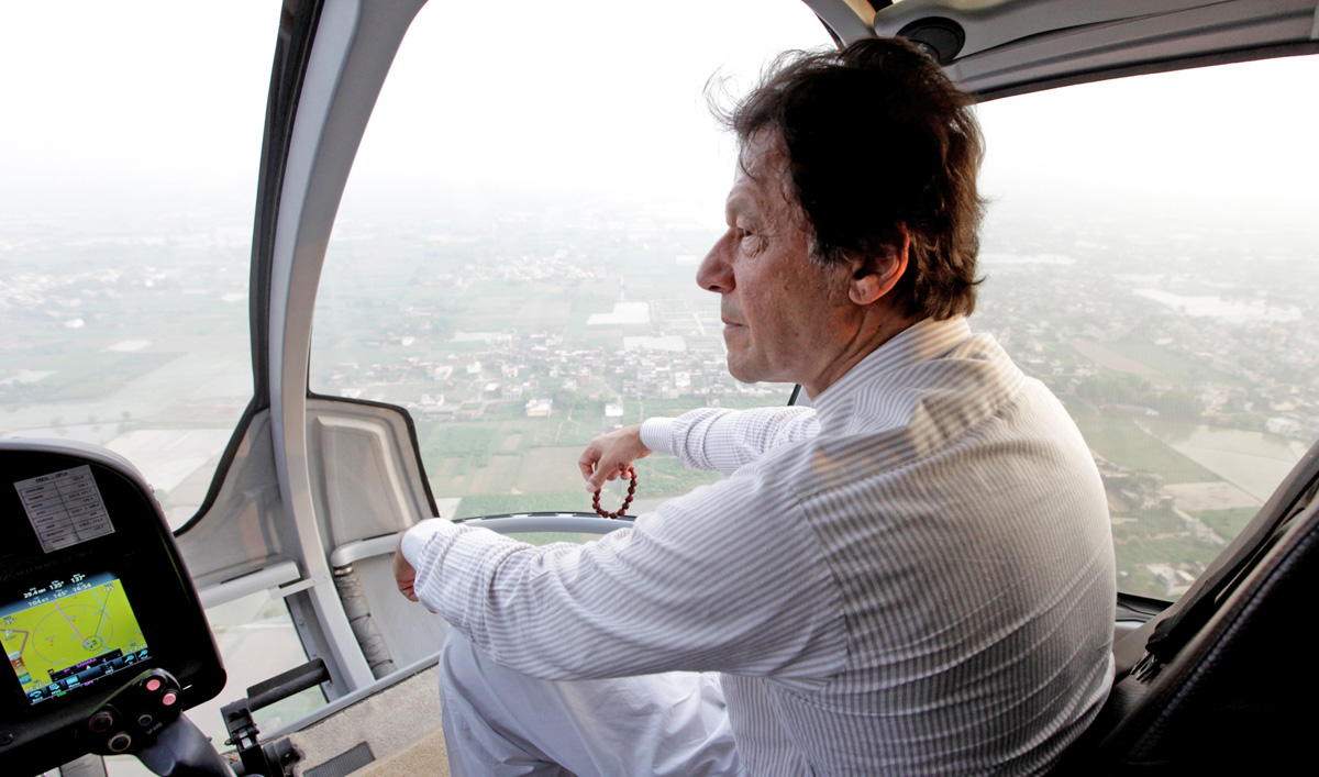 In this file photo, Imran Khan holds his tasbih, or prayer beads, as he sits in a helicopter on his way to a campaign rally ahead of general elections in Narowal, Pakistan July 12, 2018. (REUTERS)