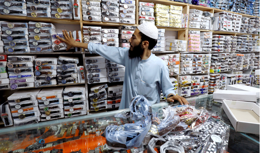 A shopkeeper pulls packs of wrist watches, imported from China, for sale at a wholesale shop in Peshawar, Pakistan on August 7, 2018. (REUTERS)