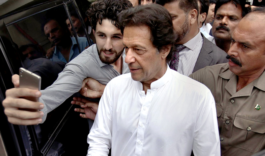 A Pakistani takes selfie with Imran Khan, center, head of the Pakistan Tehreek-e-Insaf party, as he leaves a party meeting in Islamabad, Pakistan, on Aug. 6, 2018. (AP)