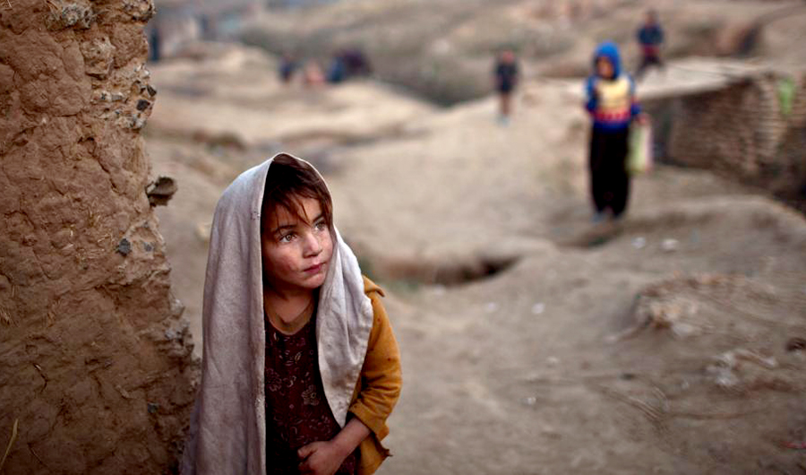 In this file photo, An Afghan girl stands by the doorway of her family's mud house on the outskirts of Islamabad, Pakistan. (AP)