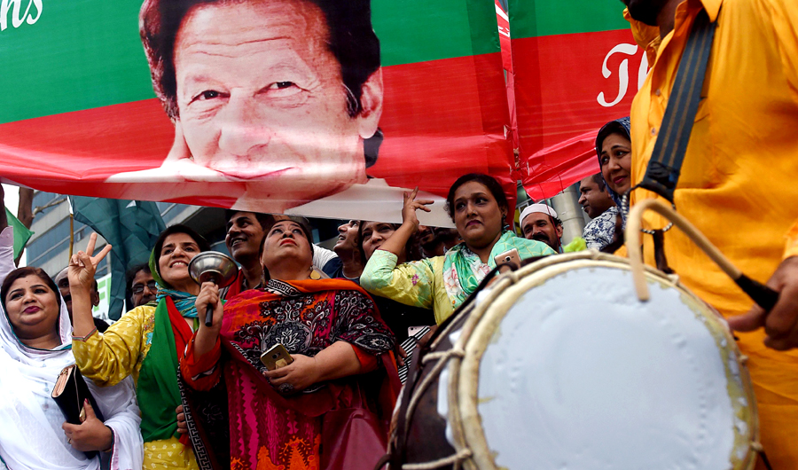 Supporters of Pakistan's cricketer-turned politician and head of the Pakistan Tehreek-e-Insaf (Movement for Justice) Imran Khan, celebrate after Khan takes oath as a Prime Minister, in Lahore on August 18, 2018. (AFP)