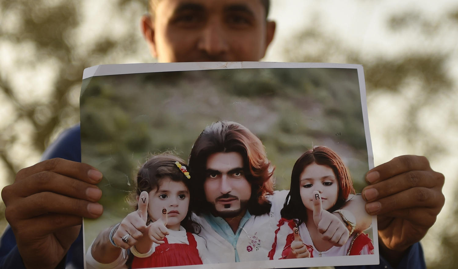 In this photograph taken on January 23, 2018, a Pakistani protester holds a photograph of 23-year-old man Naqeebullah Mehsud, during a protest in Karachi. (AFP/File)