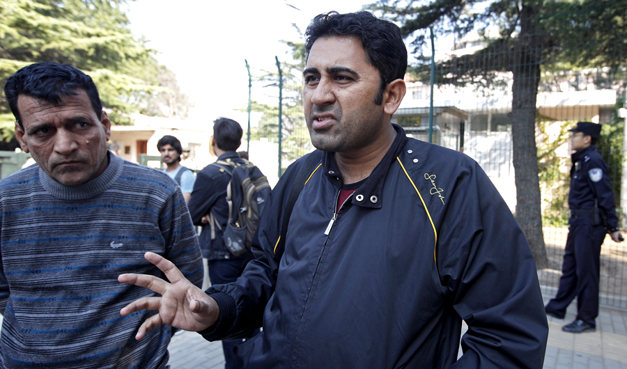 Pakistani businessman Mirza Imran Baig, right, speaks next to his compatriot outside the Pakistan's embassy in Beijing, on Wednesday, Sept. 26, 2018. (AP)