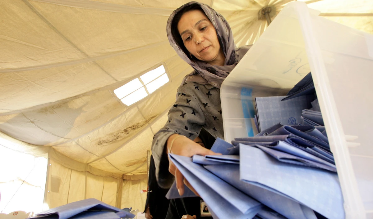 In this file photo, an Afghan election official empties a ballot box to count the numbers of ballots on the first day of the counting process inside the United Nations compound at Herat airport, Sept. 20, 2005. (AFP)