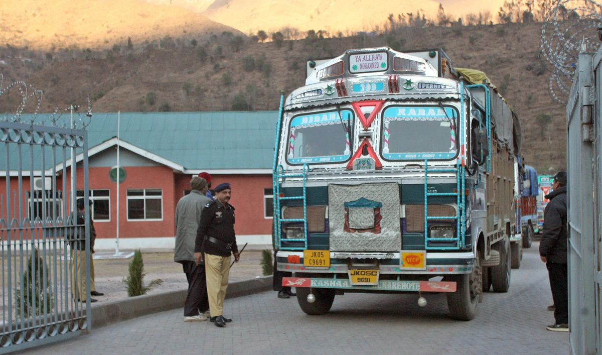 In this file photo, Pakistani policemen make way for Indian trucks as they leave the Trade Facilitation Centre before crossing the border in Chakoti, just inside Pakistan-administered Kashmir, Feb. 12, 2014. (AFP)