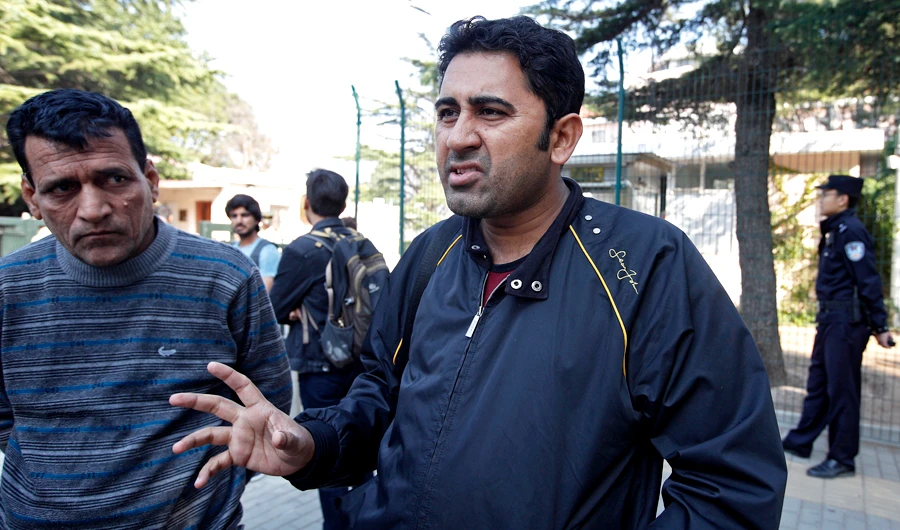 Pakistani businessman Mirza Imran Baig, right, speaks next to his compatriot outside the Pakistan's embassy in Beijing, on Wednesday, Sept. 26, 2018. (AP)