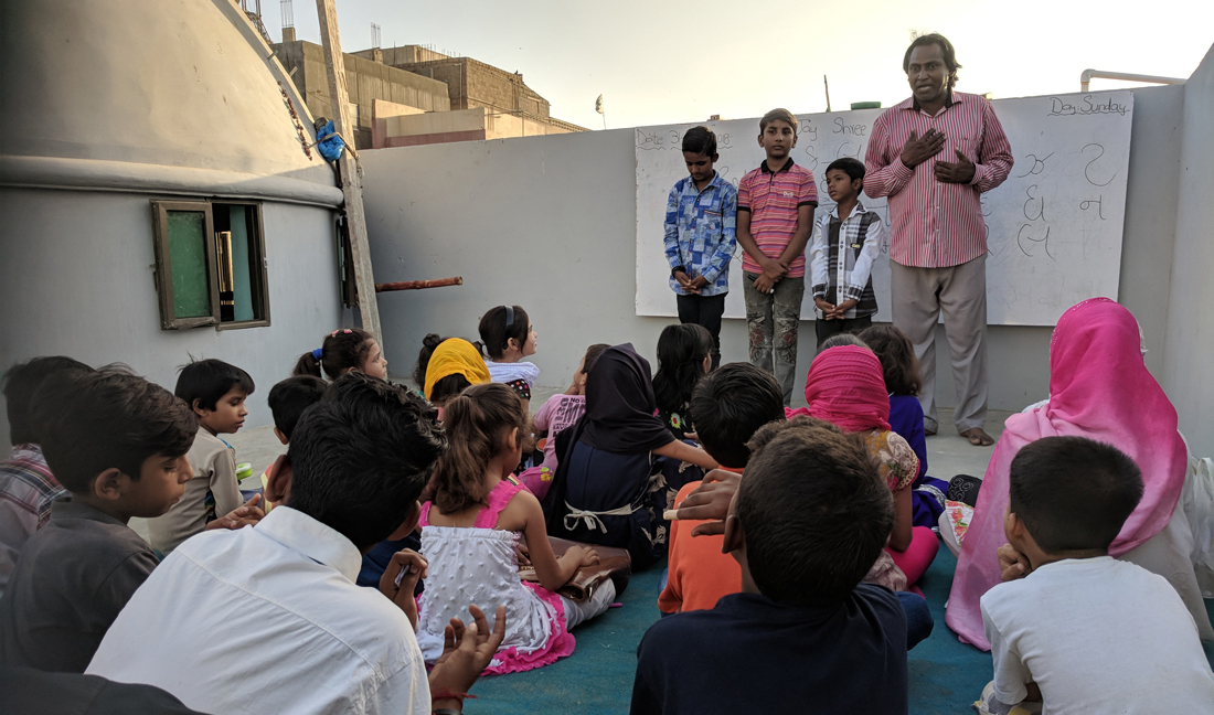 A man teaches Gujarati language to his students at the rooftop of three-story Shri Ramdev Pir temple in Soldier Bazaar area of Karachi, a Pakistani megacity housing around 3.5 million people of Gujarati descent. ( AN photo by M.F. Sabir)
