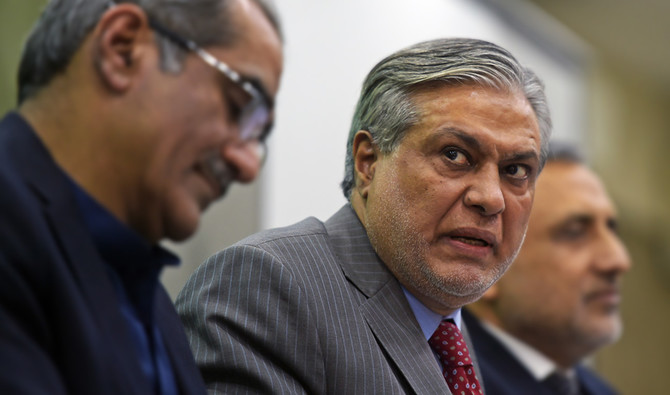 In this file photo, former Pakistani Finance Minister Ishaq Dar, center, and former Federal Minister for Railways Khawaja Saad Rafique, left, give a press conference in Islamabad on July 11, 2017. (AFP)