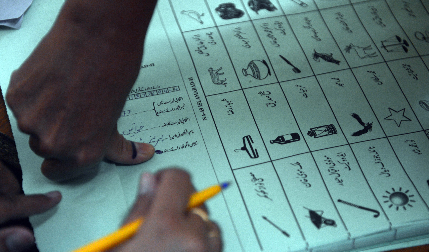 In this file photo, a Pakistani female voter presses her inked thumb onto a ballot paper before she casts her vote at a polling station in Islamabad on May 11, 2013. (AAMIR QURESHI/AFP)