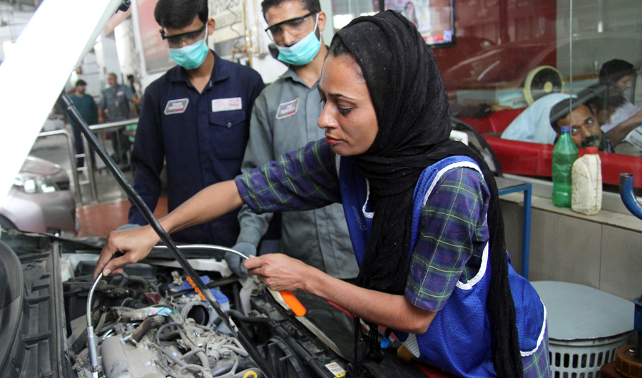 In this picture taken on Sept. 1, 2018, Pakistani motor mechanic Uzma Nawaz, 24, fixes a car at an auto workshop in Multan. (AFP)