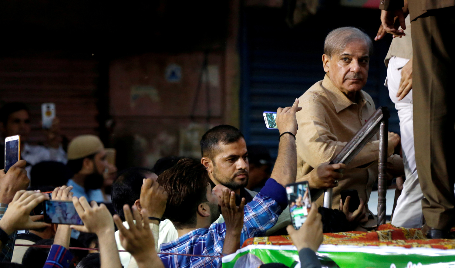 In this file photo, supporters of Shehbaz Sharif, brother of ex-prime minister Nawaz Sharif, and leader of Pakistan Muslim League - Nawaz (PML-N) use their mobile phones to take photos of him during a campaign rally ahead of general elections in the Lyari neighborhood in Karachi, Pakistan June 26, 2018. (AFP)