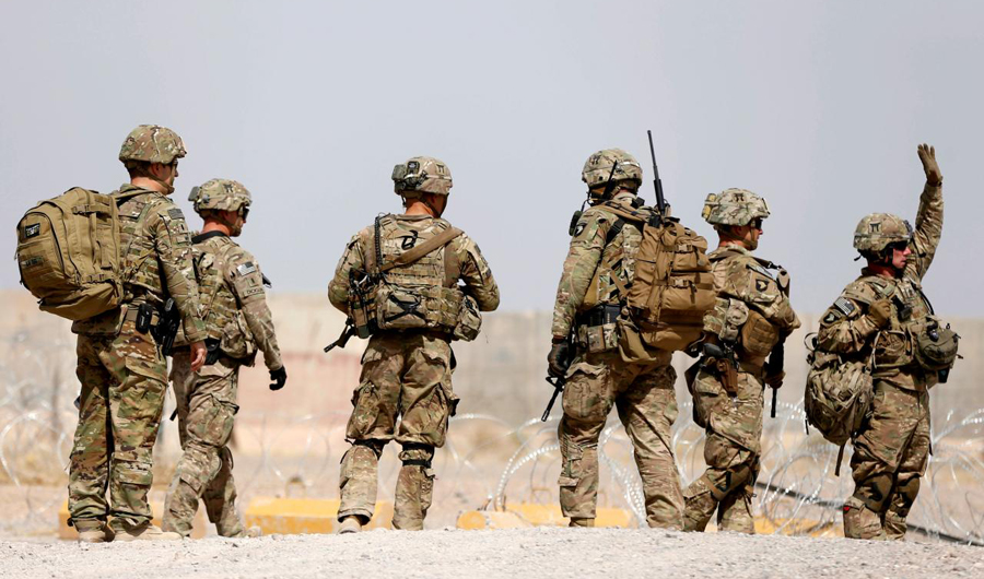 In this file photo, US troops walk outside their base in Uruzgan province, Afghanistan. (REUTERS)