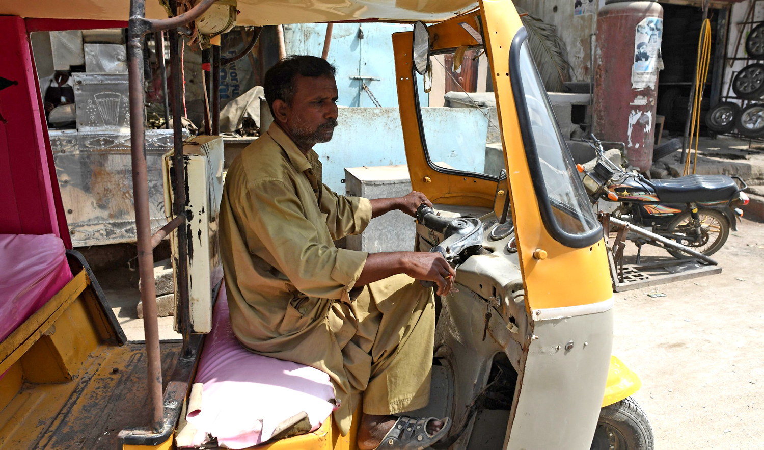 Pakistani auto-rickshaw driver Mohammad Rasheed drives his rickshaw in Qur’angi, a slum area in the eastern district of Karachi. (AFP)