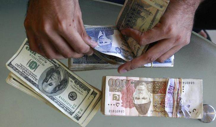 In this file photo, a currency dealer counts Pakistani rupees and U.S. dollars at his shop in Karachi October 8, 2008. (REUTERS)