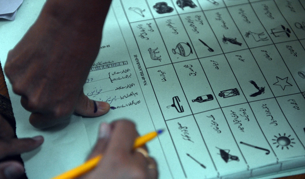 In this file photo, a Pakistani female voter presses her inked thumb onto a ballot paper before she casts her vote at a polling station in Islamabad on May 11, 2013. (AAMIR QURESHI/AFP)