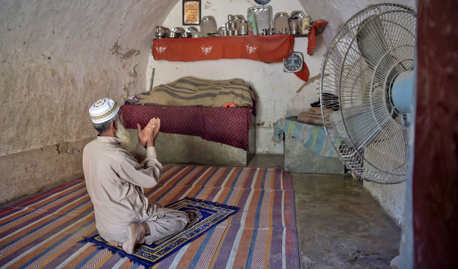In this file photo, Pakistani villager Faqeer Gul offers noon prayers in his cave room in Nikko village on Oct. 6, 2018. (AFP)
