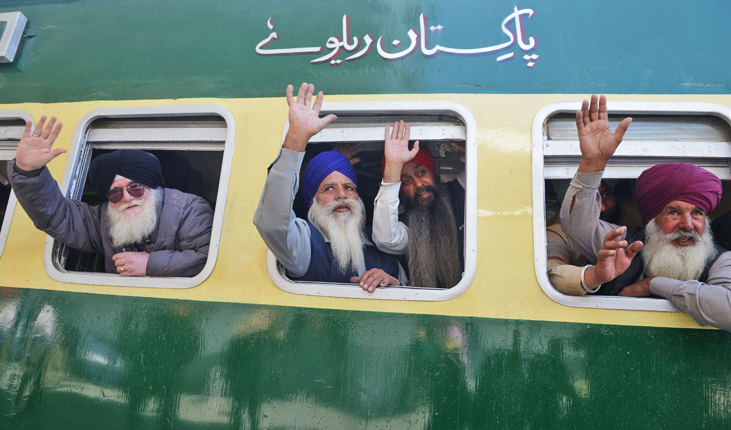 Indian Sikh pilgrims pose on a train bound for Pakistan at the railway station at Attari, some 35km from Amritsar on Nov. 21, 2018, as they prepare to leave on a Pakistani train bound for Lahore to mark the 549th birth anniversary of Guru Nanak Dev. (AFP)