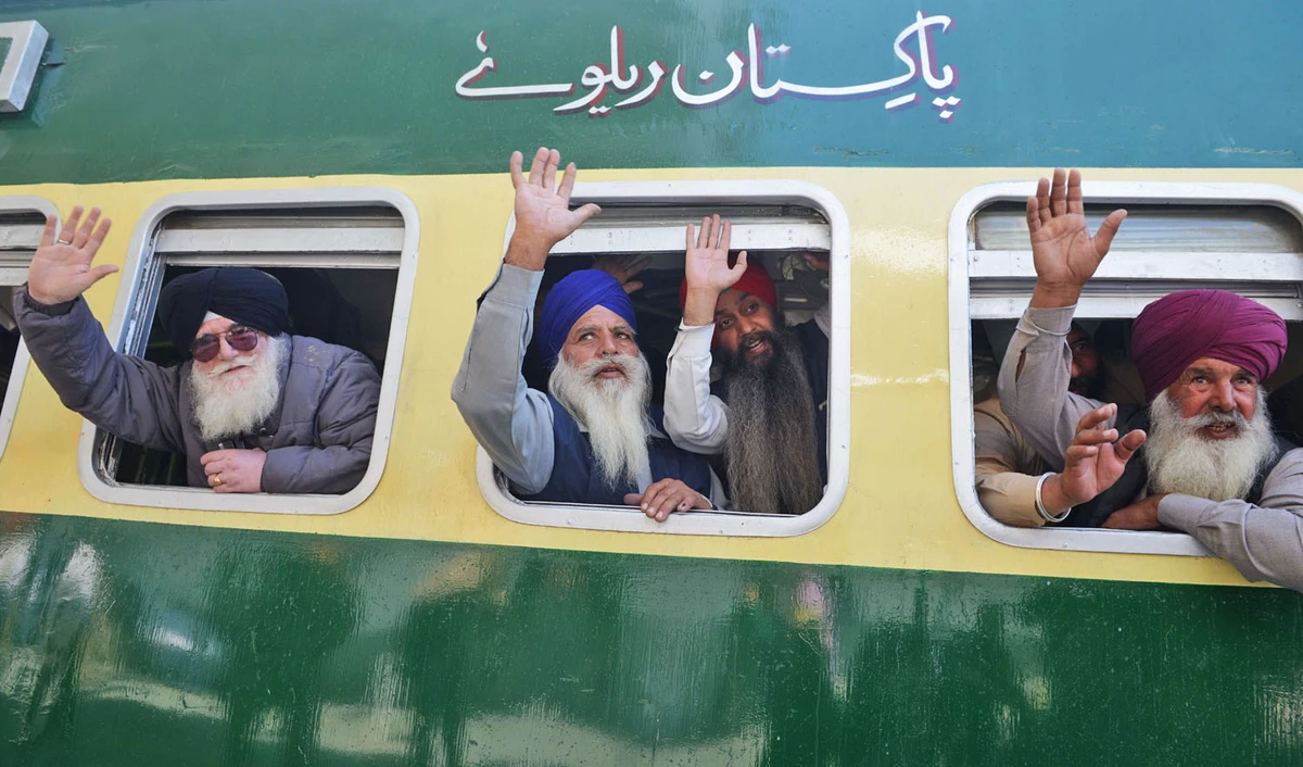 Indian Sikh pilgrims pose on a train bound for Pakistan at the railway station at Attari, some 35km from Amritsar on Nov. 21, 2018, as they prepare to leave on a Pakistani train bound for Lahore to mark the 549th birth anniversary of Guru Nanak Dev. (AFP)