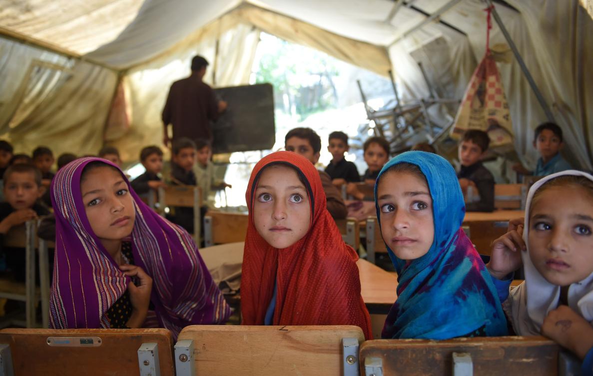 At the Tanjai Cheena school in northwest Pakistan students squeeze into makeshift classrooms where plastic tarps serve as walls and electricity is sparse. (AFP)