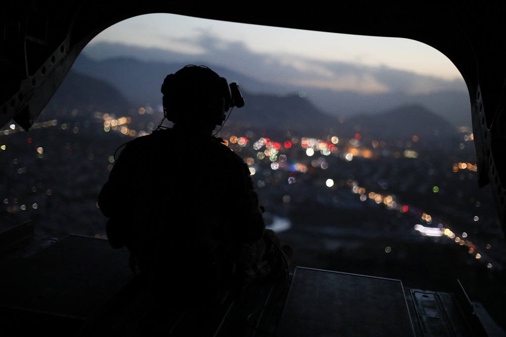 A US Army serviceman sits at the tailgate of an helicopter carrying US Defence Secretary, after leaving the Resolute Support headquarters, in the Afghan capital Kabul on April 24, 2017. (AFP)