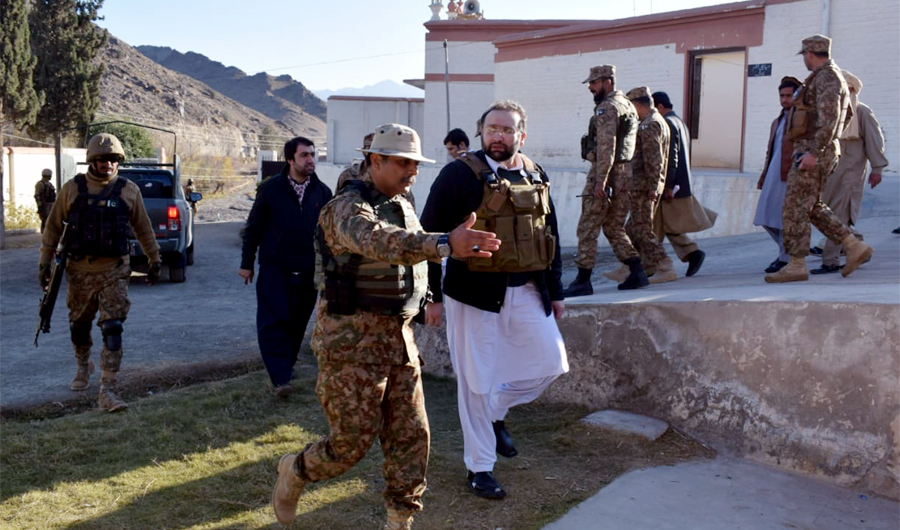 Khyber Pakhtunkhwa (KP) Health Minister Hisham Inamullah, right, being escorted by security officials after he arrives in Miran Shah, the headquarters of North Waziristan tribal district to assess health problems. (Photo by PTI media wing)