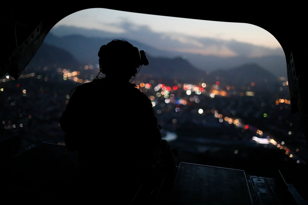 A US Army serviceman sits at the tailgate of an helicopter carrying US Defence Secretary, after leaving the Resolute Support headquarters, in the Afghan capital Kabul on April 24, 2017. (AFP)