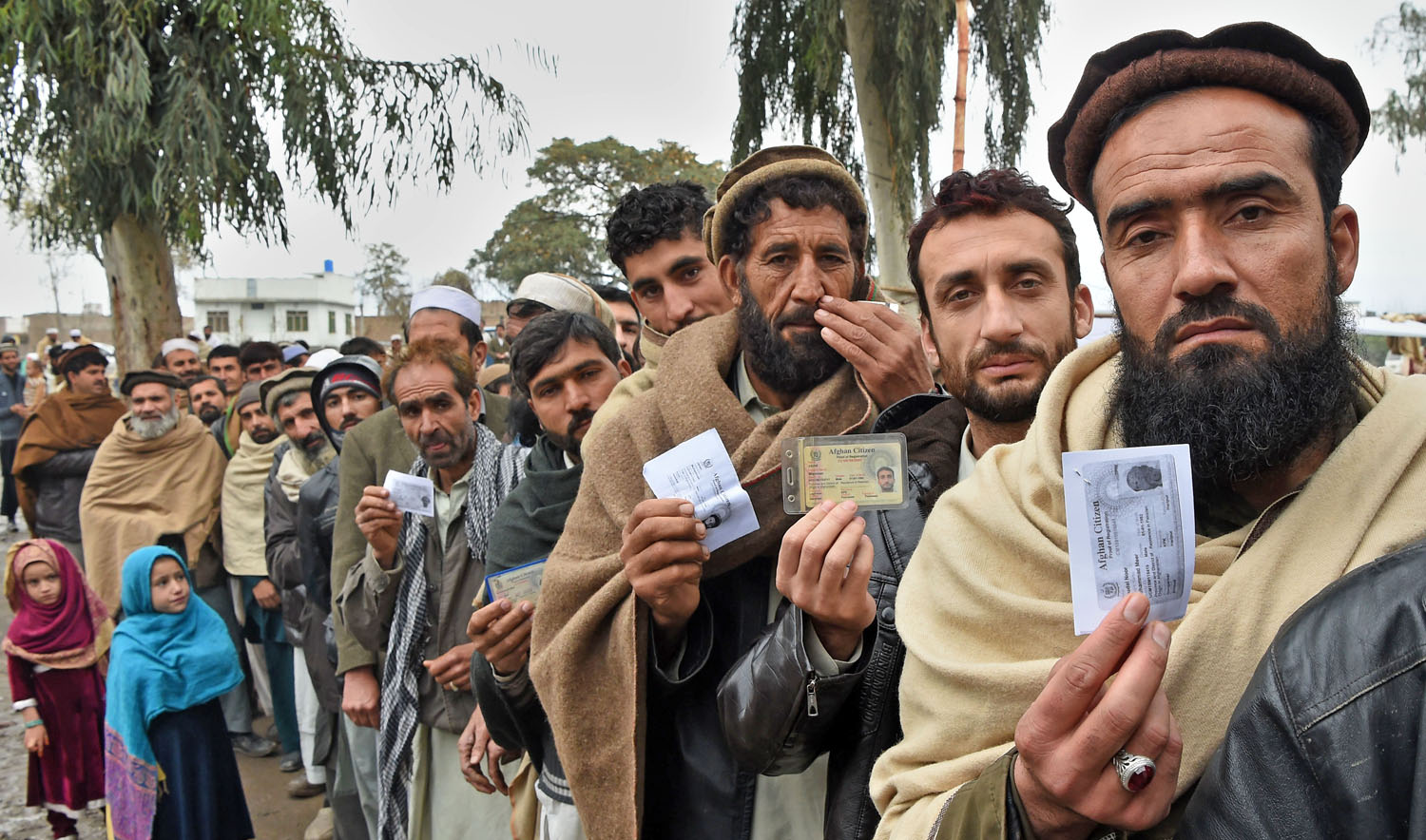 Afghan refugees queue up in Peshawar with identity cards in hand. (AFP/File)
