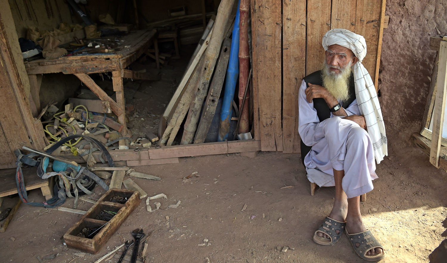 In this file photo, an elder Afghan refugee sits outside a shop at a refugee camp on the outskirts of Islamabad on Oct. 18, 2018. Pakistan is one of the largest refugee-hosting nations in the world, but many Pakistanis have long viewed Afghan refugees in particular suspiciously. (AFP)