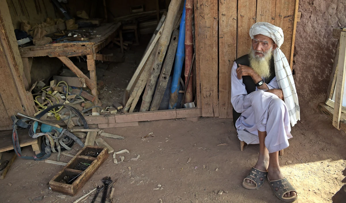 In this file photo, an elder Afghan refugee sits outside a shop at a refugee camp on the outskirts of Islamabad on Oct. 18, 2018. Pakistan is one of the largest refugee-hosting nations in the world, but many Pakistanis have long viewed Afghan refugees in particular suspiciously. (AFP)