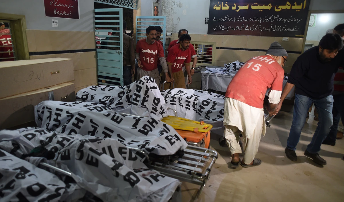 Pakistani volunteers handle the burnt remains of bus passengers at an Edhi Foundation mortuary in Karachi on January 22, 2019, following a transport accident. (AFP)
