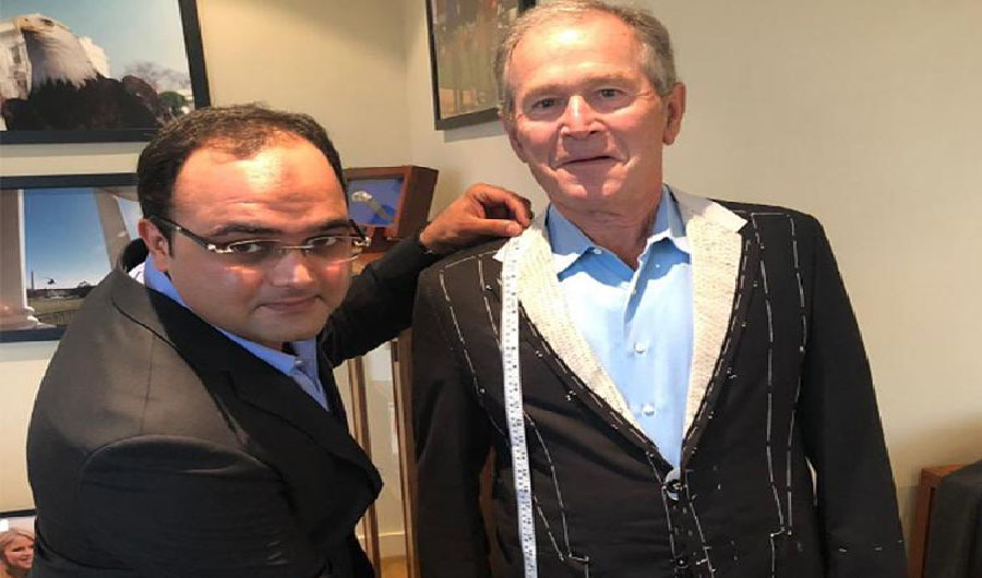 Sarfraz Akbar is taking measurement of former President George W. Bush for his suits (Photo Courtesy Social Media)