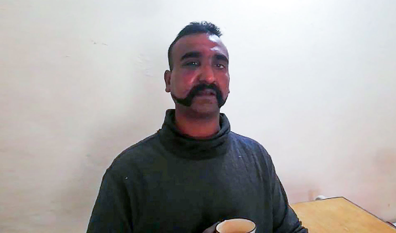 This handout photograph released by Pakistan's Inter-Services Public Relations (ISPR) on February 27, 2019, shows captured Indian pilot looking on as holding a cup of tea in the custody of Pakistani forces in an undisclosed location. (ISPR via AFP)