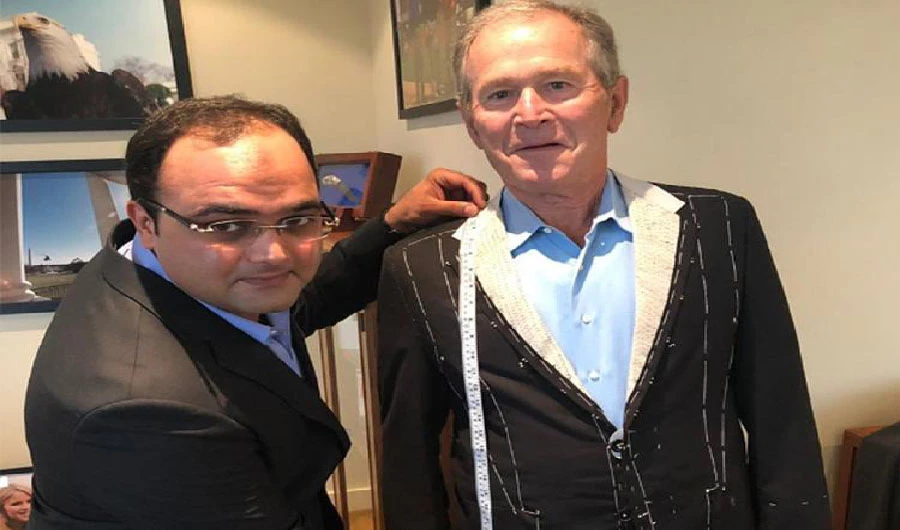 Sarfraz Akbar is taking measurement of former President George W. Bush for his suits (Photo Courtesy Social Media)