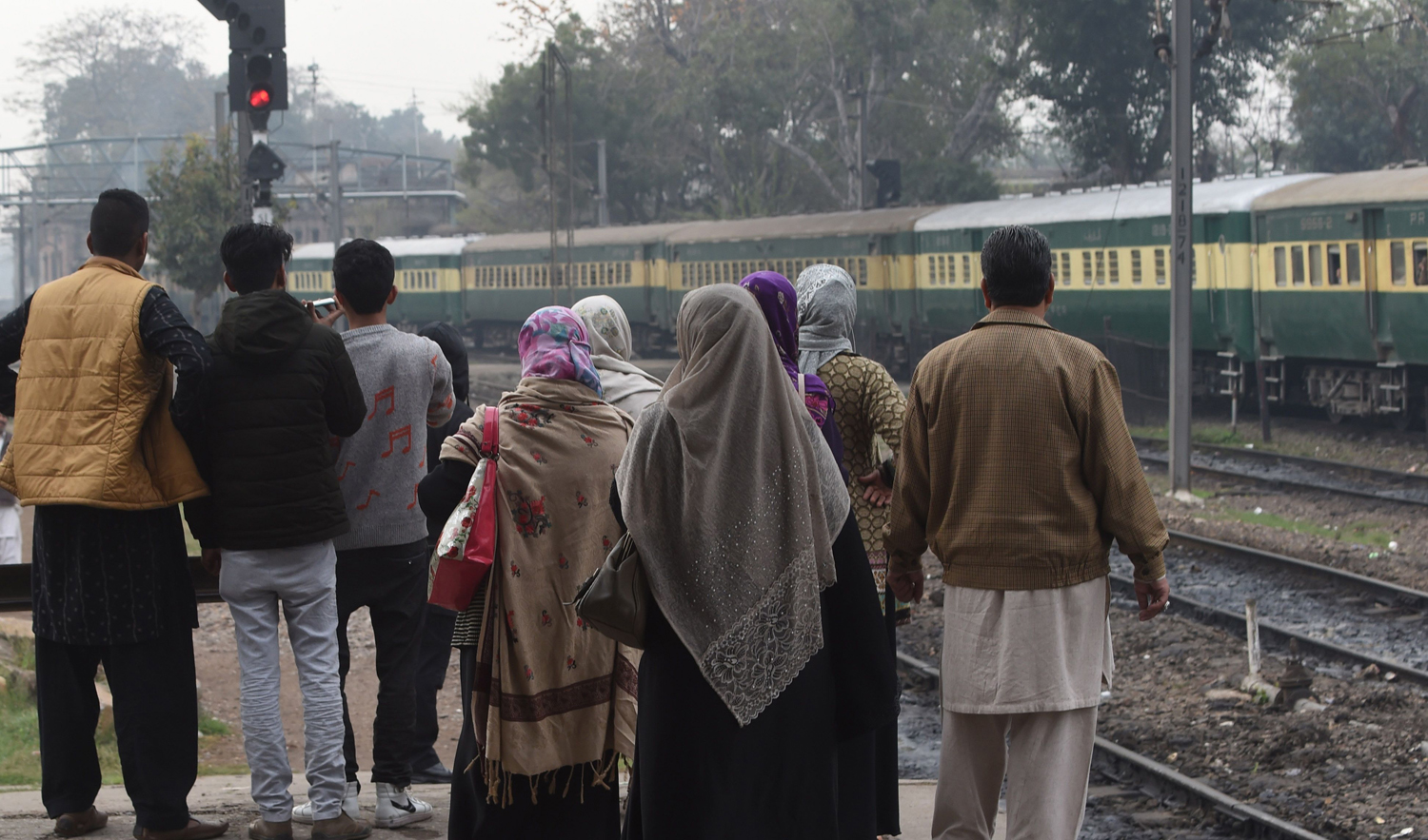 Pakistani people watch the Samjhauta Express, also called the Friendship Express that runs between New Delhi and Attari in India and Lahore in Pakistan, carrying their Indian relatives as it departs Lahore railway station on March 4, 2019, after the rail service was restored following days of tension between India and Pakistan. (AFP)