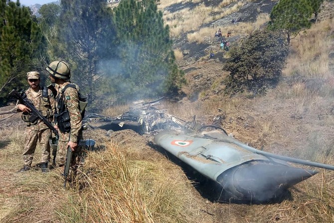 Pakistani soldiers stand next to what Pakistan says is the wreckage of an Indian fighter jet shot down in Pakistan controled Kashmir at Somani area in Bhimbar district near the Line of Control on February 27, 2019. (AFP)