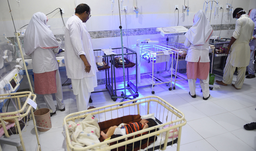 In this picture taken on May 25, 2018, Pakistani medics take care of children at Mithi Civil Hospital in Mithi, a remote town in southern Pakistan. A frantic mother cradling her seven-month-old baby rushes towards the special paediatric ward in a desolate Pakistan town, his eyes are blank and he is smaller than most newborns. (AFP)