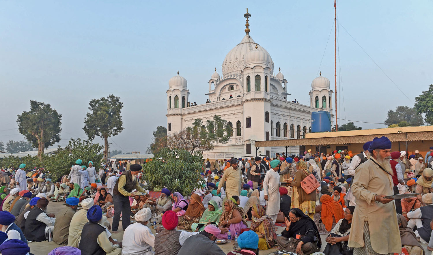 In this file photo, Sikh Pilgrims eat food in front of Kartarpur Gurdwara Sahib after a groundbreaking ceremony for the Kartarpur Corridor in Kartarpur on Nov. 28, 2018. (AFP)